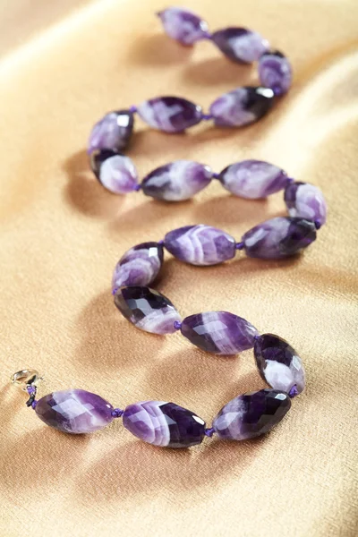 Beads from violet glass against from a fabric — Stock Photo, Image