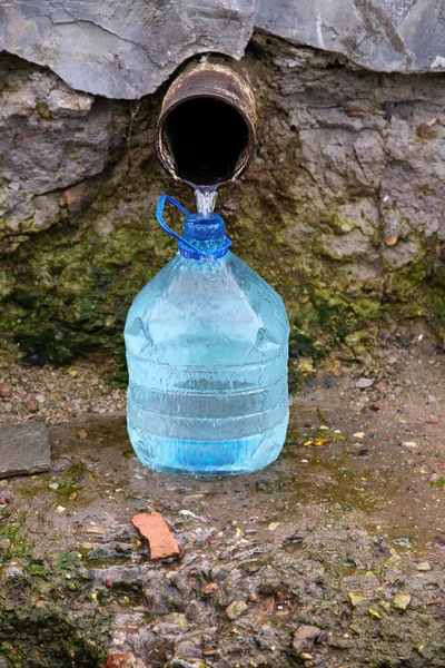 Source naturelle d'eau et bouteille en plastique — Photo