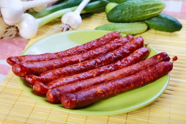 Bodegón con salchichas fritas, ajo y pepinos — Foto de Stock