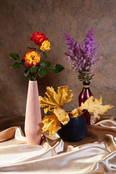 Natureza morta com rosas e folhas de bordo secas em vasos — Fotografia de Stock