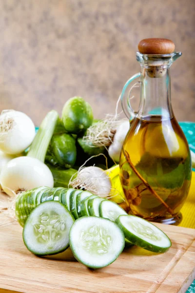 Cebola de pepino e alho com uma garrafa de azeite em uma cozinha — Fotografia de Stock