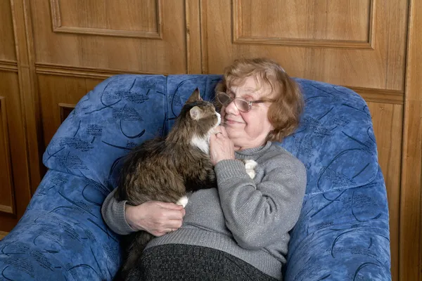 La abuela con el gato en las condiciones de casa Imágenes de stock libres de derechos