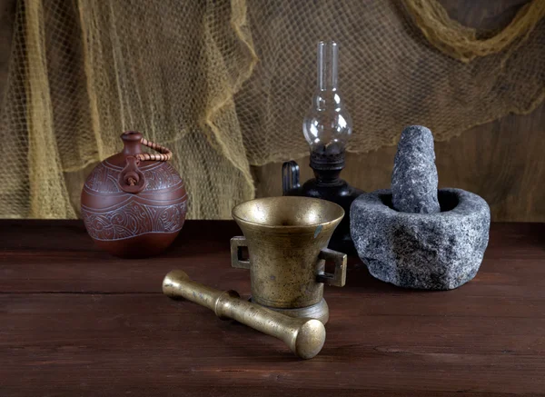 Still-life with mortars and an oil lamp on an old table — Stock Photo, Image
