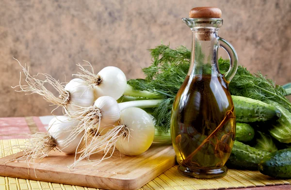 Still-life with onions cucumbers and olive oil — Stock Photo, Image