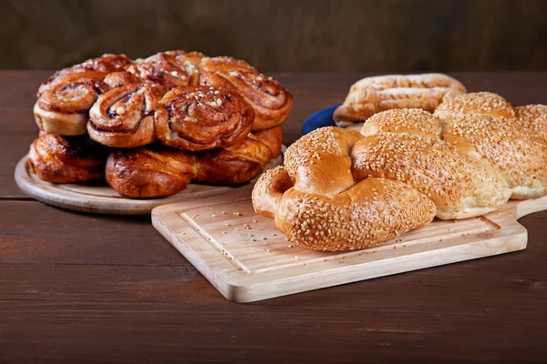 Stillleben mit Brötchen und Torten auf dem Küchentisch — Stockfoto