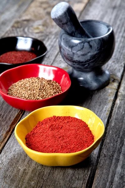 Kryddor och mortel med mortelstöt på ett bord — Stockfoto