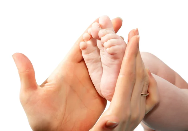 Las manos de la madre sostienen las piernas del bebé sobre un fondo blanco — Foto de Stock