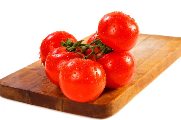 Rama de tomates con gotas de agua sobre un fondo blanco — Foto de Stock