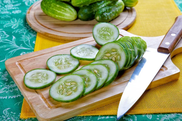 Still-life with the cut cucumbers an onions and garlic — Stock Photo, Image