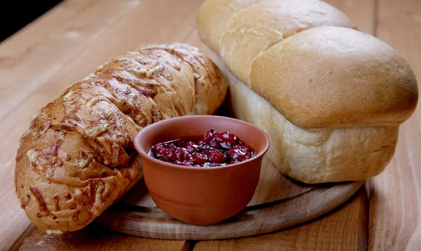 Long loaf of bread and jam on a table — Stock Photo, Image
