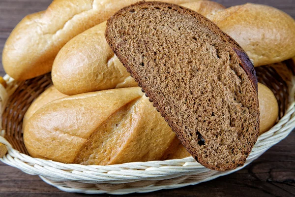 Siyah ekmek ve beyaz rulo bir dilim ile natürmort — Stok fotoğraf