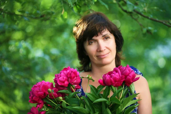 Mujer en un jardín con ramo de flores enfoque suave — Foto de Stock