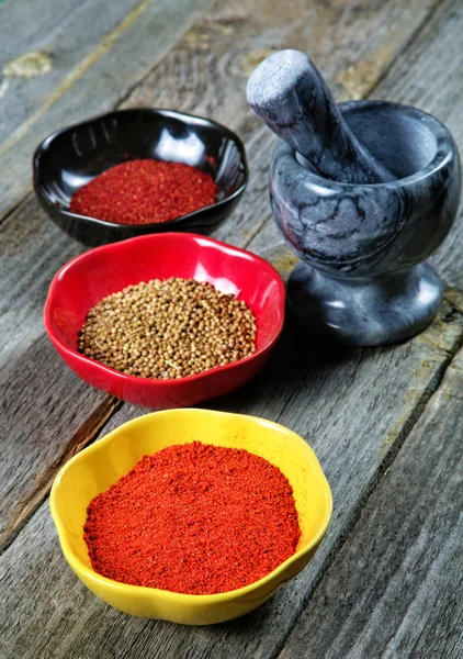 Mortar and plates with spices on an old table — Stock Photo, Image