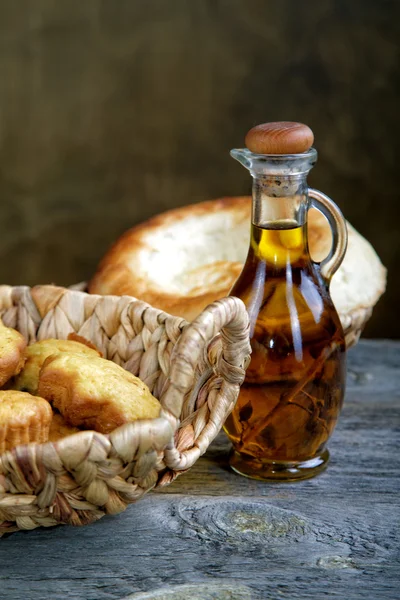 Хліб у кошику та пляшка оливкової олії — стокове фото