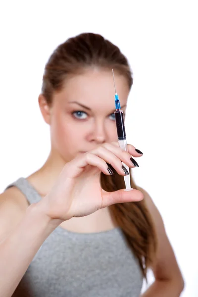 Mädchen über eine Spritze in der Hand auf weißem Hintergrund — Stockfoto