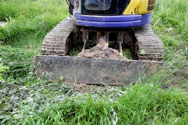 La excavadora presiona una hierba verde —  Fotos de Stock