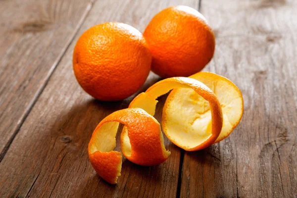 Naranjas y cáscara seca sobre una mesa rural — Foto de Stock