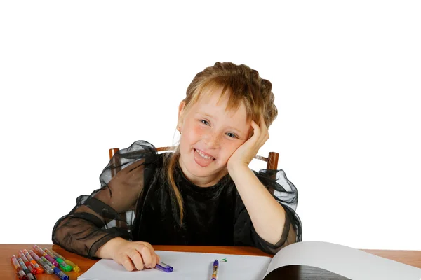 La fille s'assied à une table et sort la langue — Photo