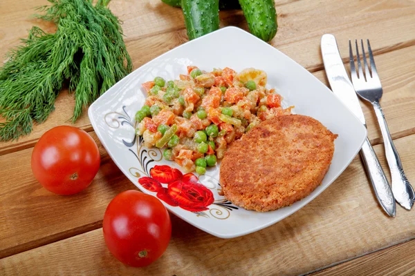 Vis kotelet met groenten op een landelijke tafel — Stockfoto