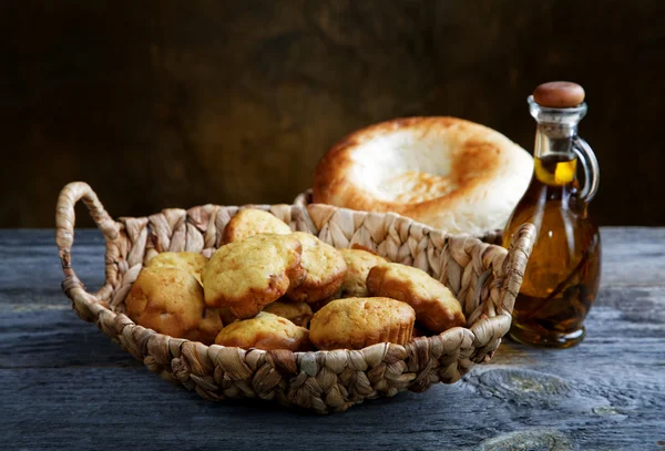 Bröd i en korg och en flaska olivolja — Stockfoto