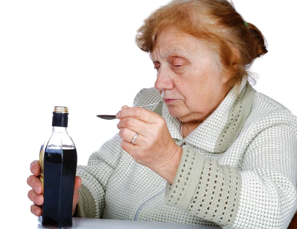 The old woman pours a liquid in the spoon — Stock Photo, Image