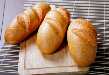 üç uzun bir kesme tahtası üzerinde loafs