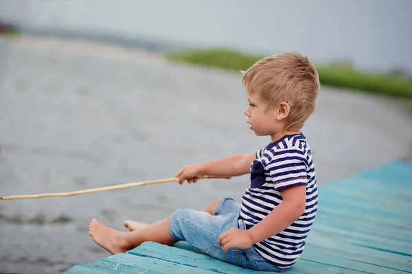 Menino de quatro no molhe pelo mar — Fotografia de Stock