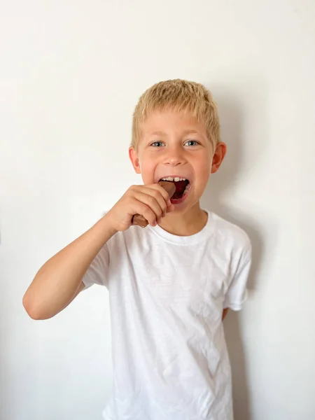 Χαριτωμένο Χαμογελαστό Αγόρι Στο Δωμάτιό Του Κρατώντας Μια Σοκολάτα — Φωτογραφία Αρχείου
