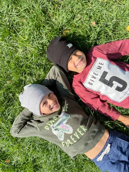 两个可爱的孩子躺在草地上 — 图库照片