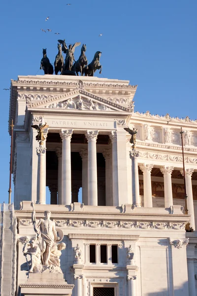 Dark statue and white building — Stock Photo, Image