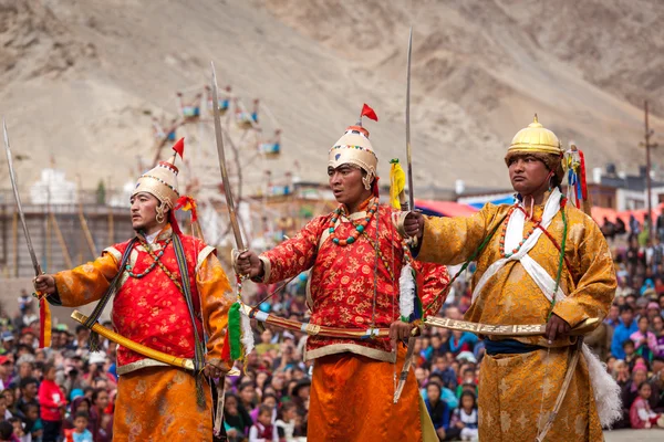 Танцоры в традиционных ладакхских тибетских костюмах ведут себя воинственно — стоковое фото
