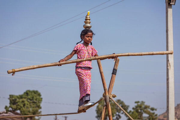 Unidentified indian girl street acrobat walks