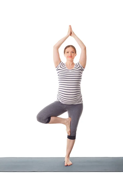 Pregnant woman doing yoga asana Vrikshasana — Stock Photo, Image