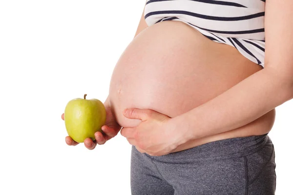 Schwangere steht und hält Apfel am Bauch — Stockfoto