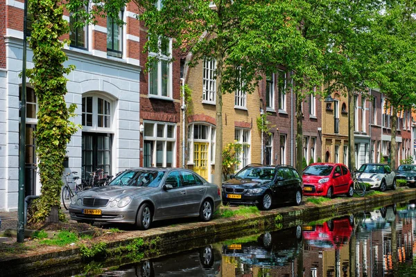 Delft caddesindeki kanal kenarındaki araçlar. Delft, Hollanda — Stok fotoğraf