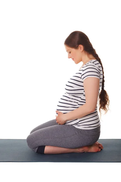 妊娠中のヨガの練習 妊娠中の女性はヨガAsana Virasanaヒーローポーズ膝の上に白い背景に隔離 — ストック写真