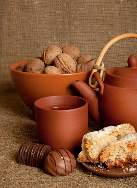 Clay teapot with sweets — Stock Photo, Image