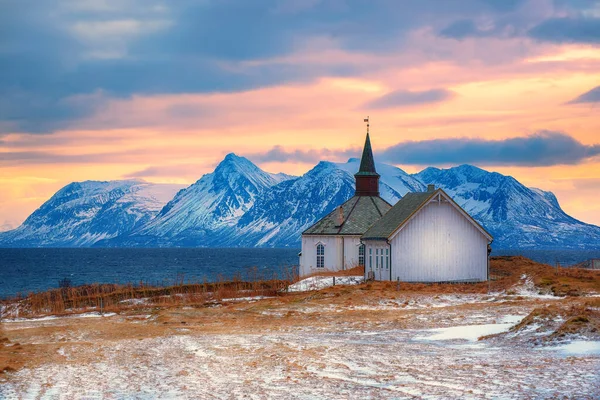 ノルウェー北部のロフトテン島の教会 山と劇的な空と海の海岸に木製の小さな大聖堂と冬の風景 — ストック写真
