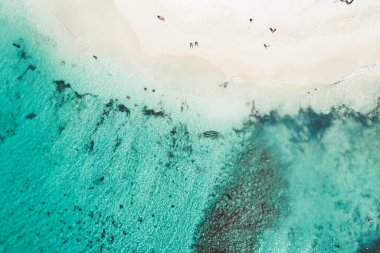 Dominik Cumhuriyeti 'ndeki güzel Karayip plajı. Küçük insan figürleri, deniz kıyıları ve beyaz kumdan oluşan tropikal sakin yaz manzarasının havadan soyut görüntüsü