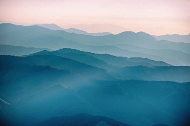 Karpat Dağları yaz günbatımı manzarası soyut dağ tepelerinin mavi renkleriyle gradyanı, doğal seyahat arka planı