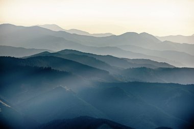 Karpat Dağları yaz günbatımı manzarası soyut dağ tepelerinin mavi renkleriyle gradyanı, doğal seyahat arka planı
