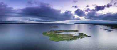 Kırsal yaz günbatımı manzarası nehir, küçük ada ve dramatik renkli gökyüzü, doğal arka plan, havadan panoramik manzara