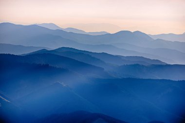 Karpat Dağları yaz günbatımı manzarası soyut dağ tepelerinin mavi renkleriyle gradyanı, doğal seyahat arka planı