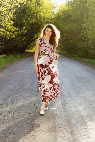 Mujer joven caminando en el camino — Foto de Stock