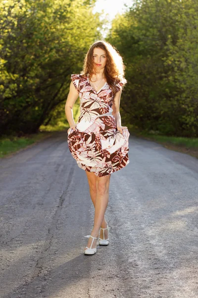 Beautiful woman walking on the road — Stock Photo, Image