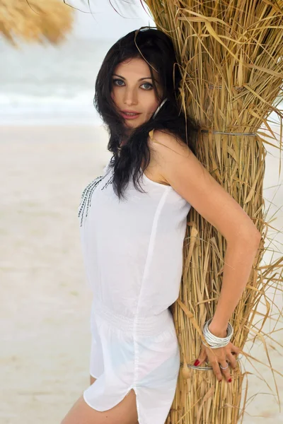 Vacker ung brunett på en strand — Stockfoto