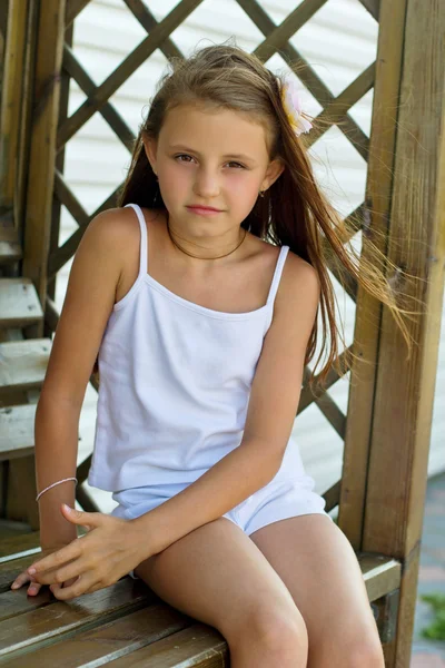 Girl sitting on a wooden bench — Stock Photo, Image