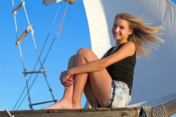 Tonåring flicka sitter vid aktern av fartyget — Stockfoto