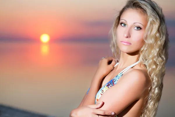 Lächelnde blonde Frau posiert bei Sonnenuntergang — Stockfoto