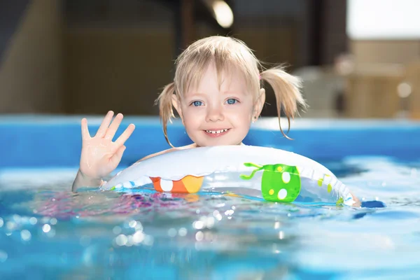 Piccola ragazza bionda nuotare in piscina d'acqua — Foto Stock